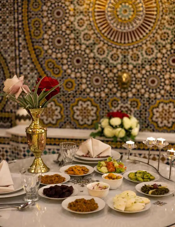 Table marocaine dressée devant une fontaine en zelliges